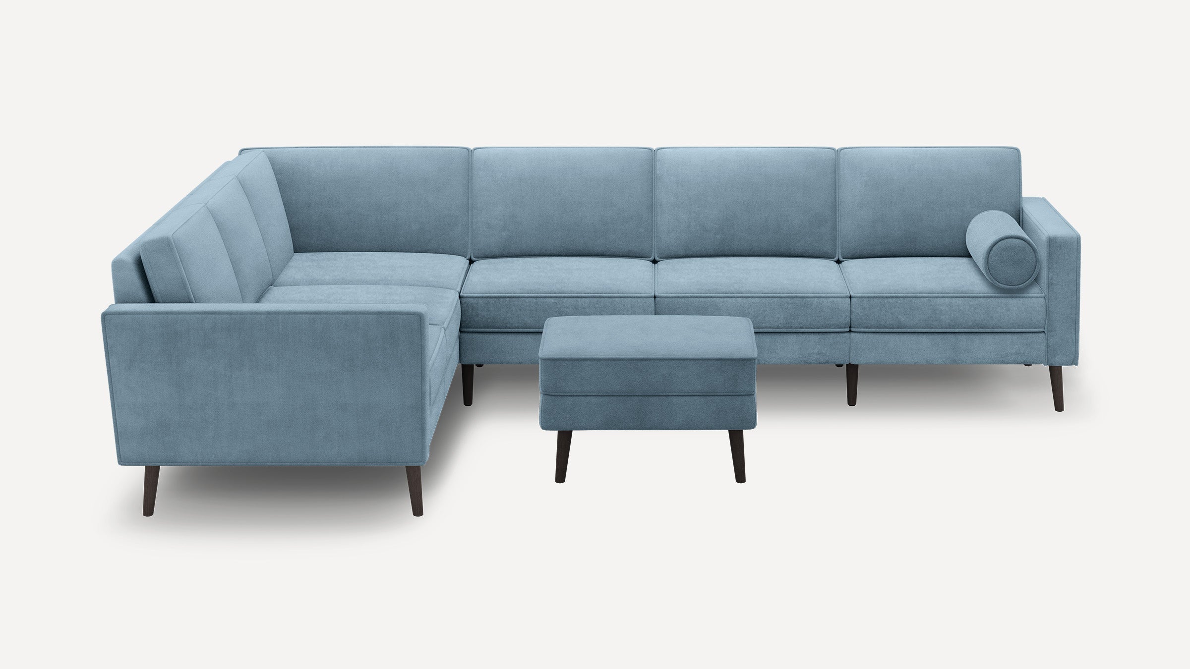 Light blue velvet L-shaped sectional sofa with dark wooden legs and matching rectangular ottoman.