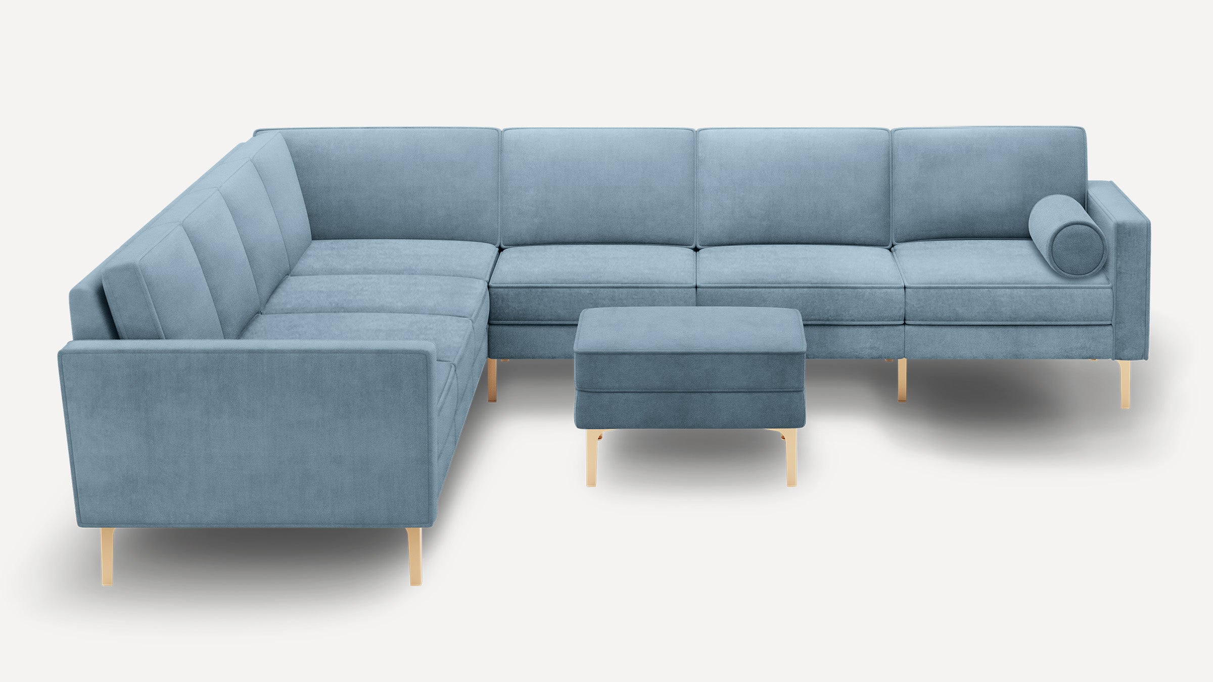 Light blue L-shaped sectional sofa with gold metal legs, included matching ottoman, and cylindrical bolster pillow on right side.