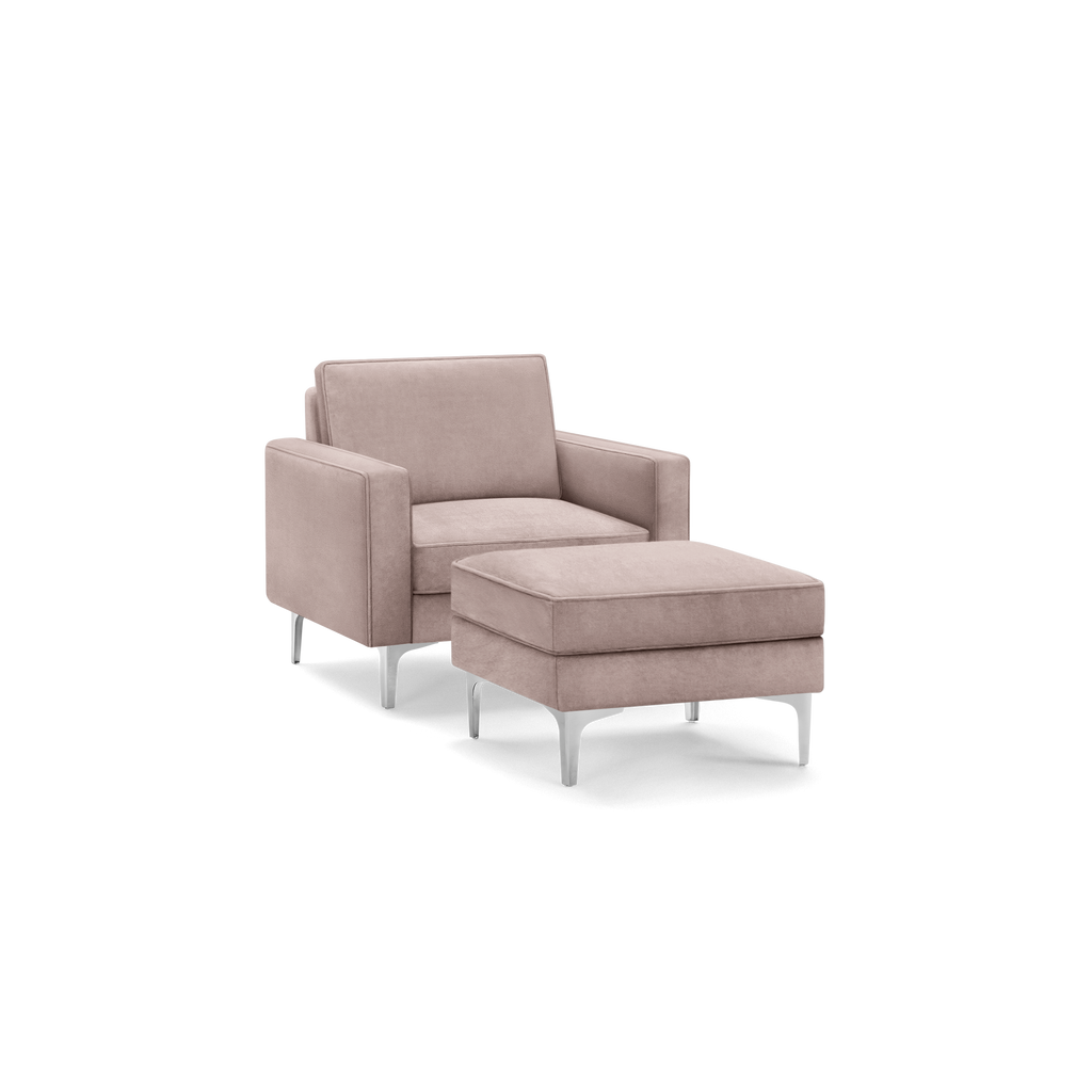 Modern blush pink velvet armchair with matching ottoman, featuring sleek silver metal legs and clean, boxy design.