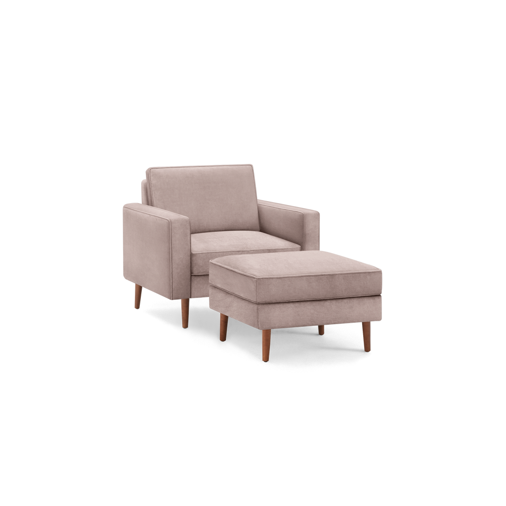 Light mauve modern armchair with a matching cushioned ottoman, both featuring wooden tapered legs.