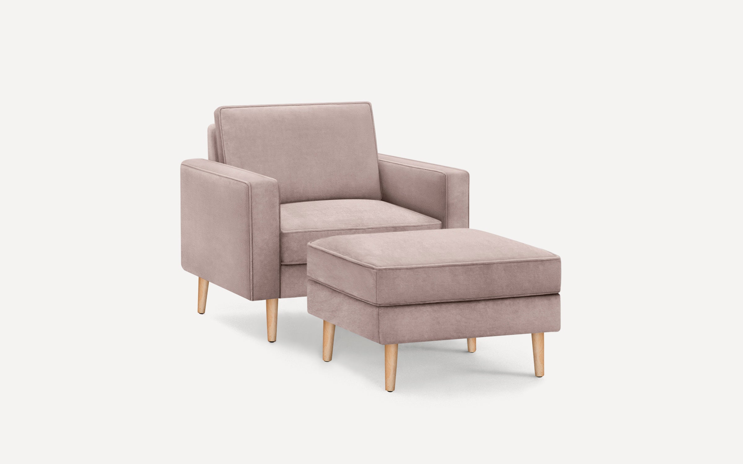 Modern dusty pink upholstered armchair with matching ottoman, both featuring light wooden legs and a minimalist design.