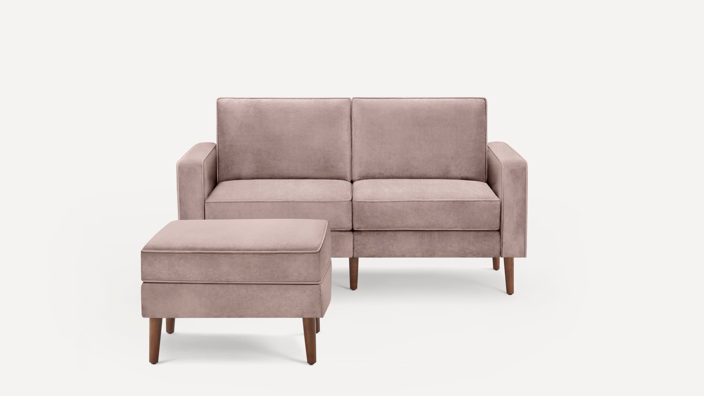 Light mauve velvet loveseat with matching ottoman, both featuring wooden legs and clean, modern design.
