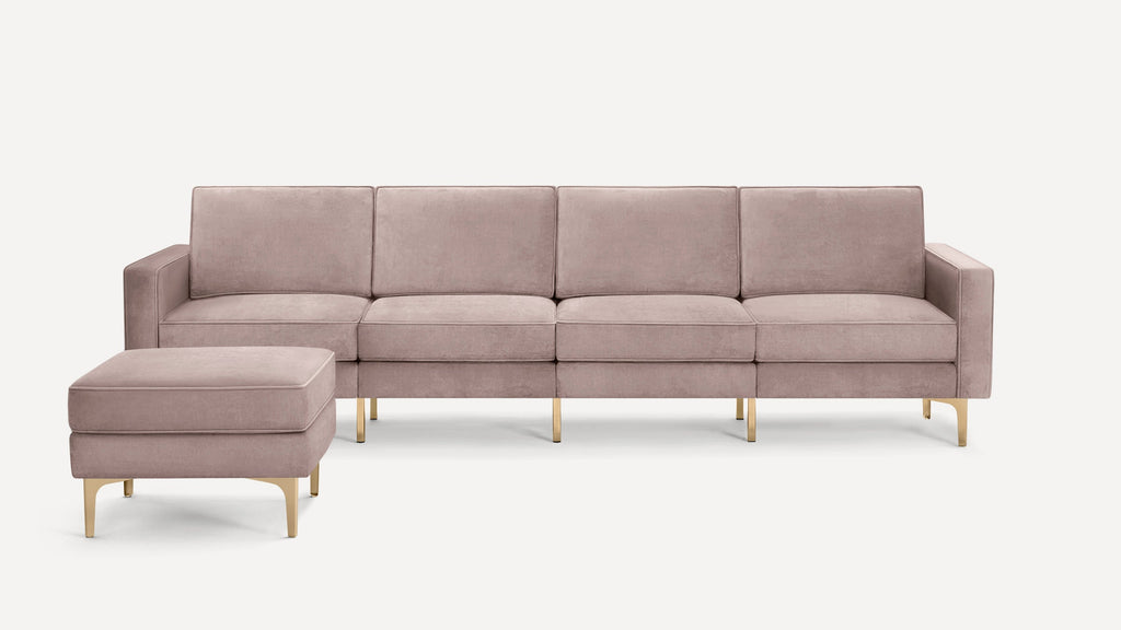 Modern four-seat sofa with matching ottoman in soft mauve velvet fabric and gold metal legs.