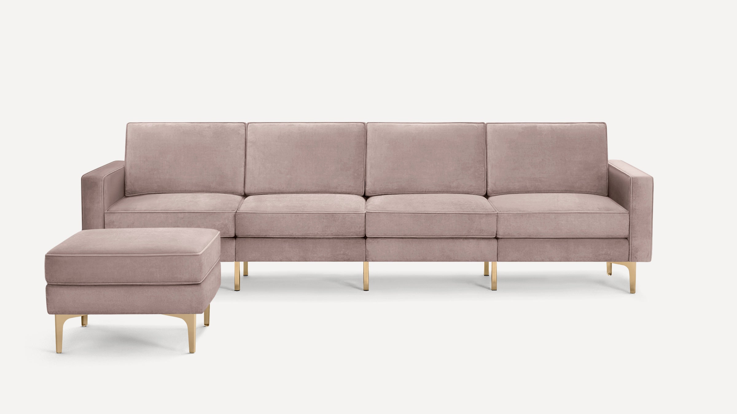 Modern four-seat sofa with matching ottoman in soft mauve velvet fabric and gold metal legs.