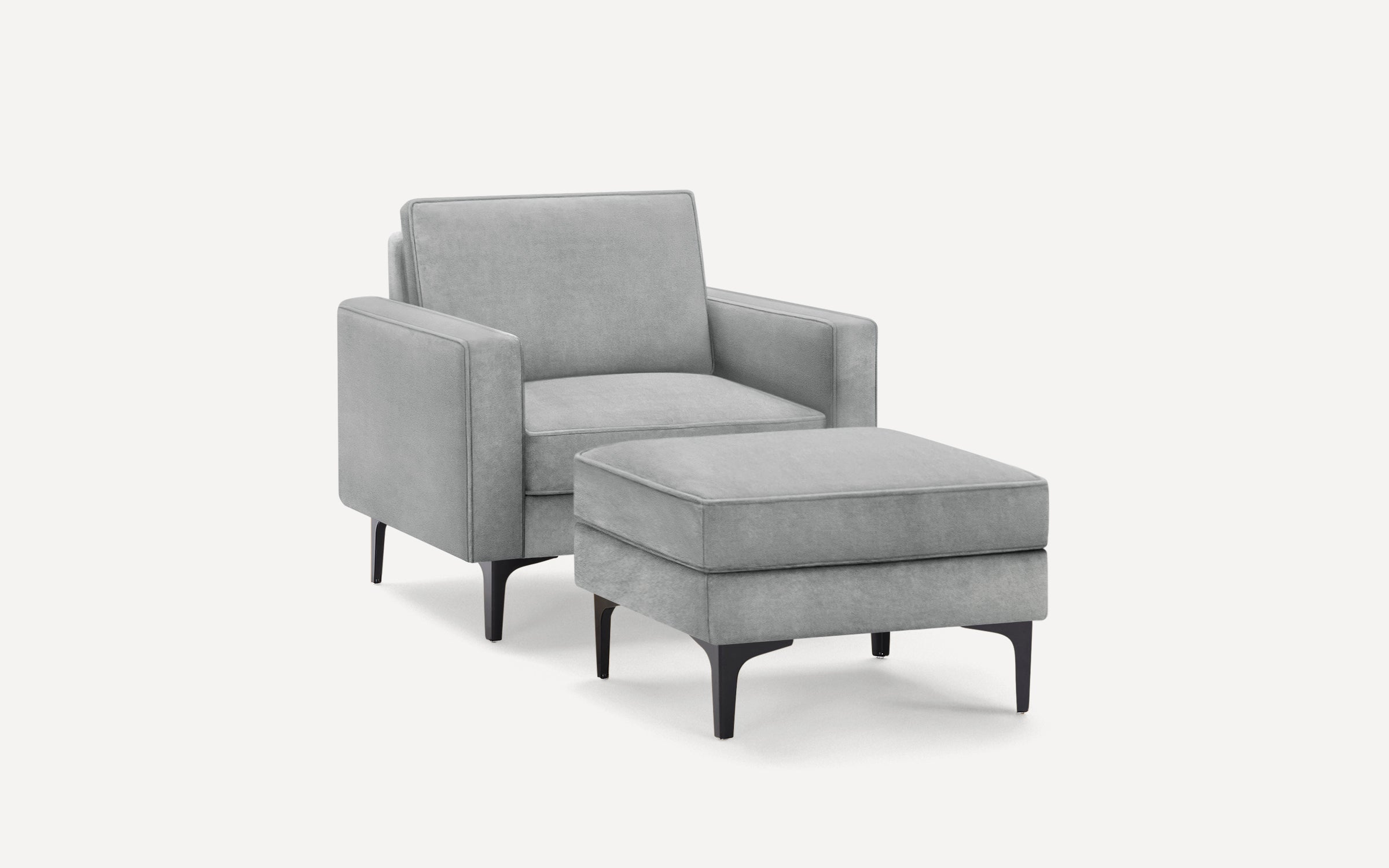 Modern gray upholstered armchair with matching ottoman, featuring sleek black tapered legs and clean, minimalist design.