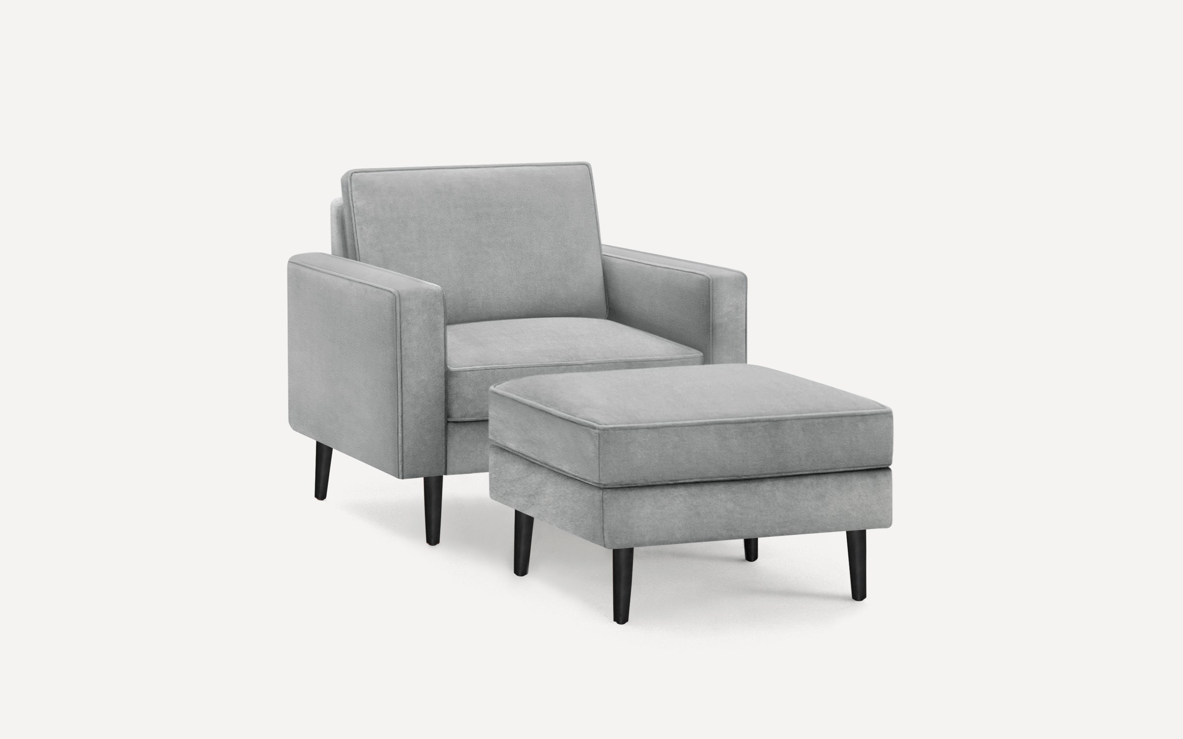 Modern light gray upholstered armchair with matching ottoman, both featuring black tapered wooden legs.