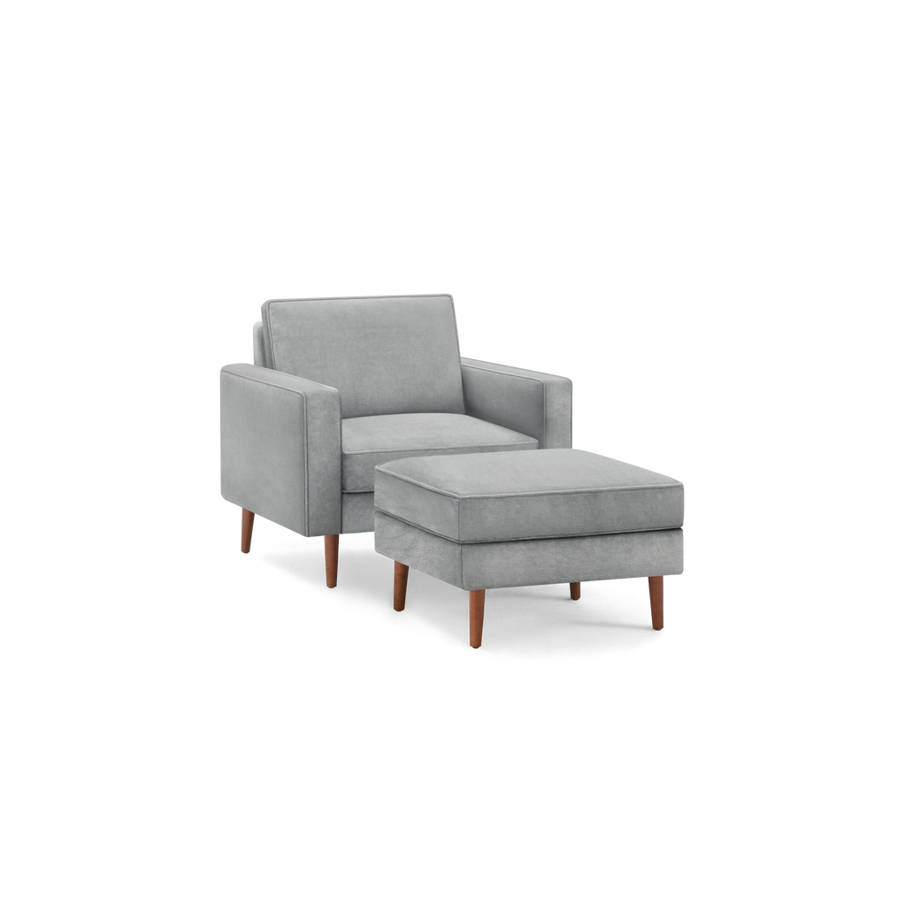 modern light gray upholstered armchair with matching ottoman, featuring tapered wooden legs and a sleek backrest