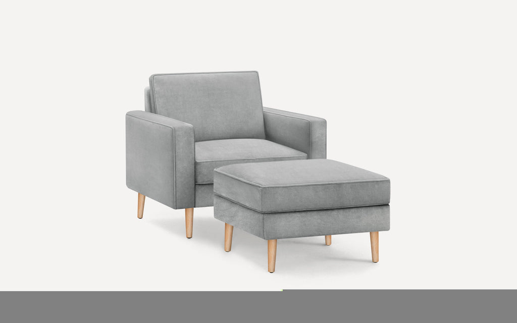 Modern light gray armchair with matching ottoman, featuring clean lines and wooden tapered legs.