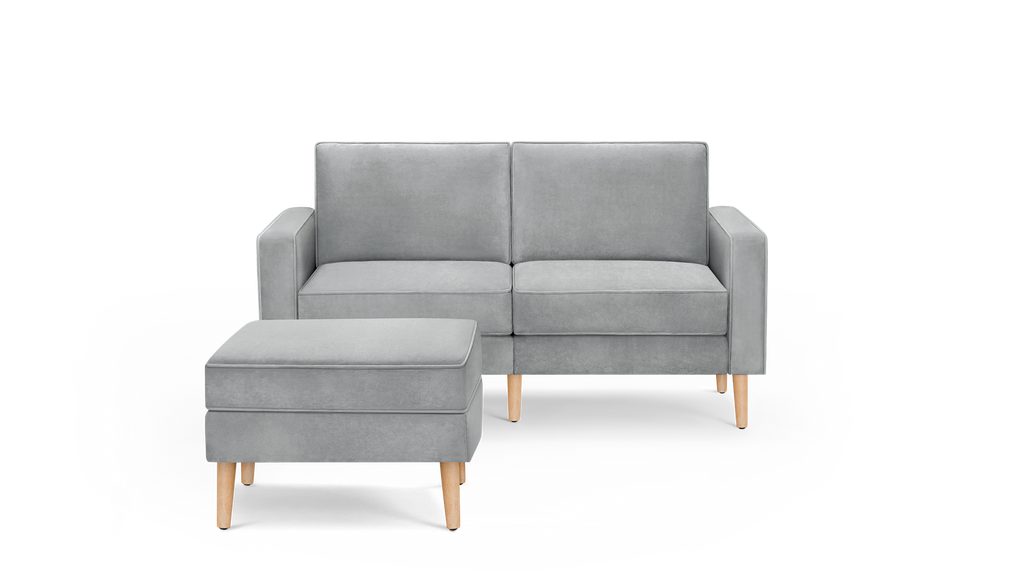 modern light gray velvet upholstered sofa with matching ottoman and wooden legs, featuring a sleek design and clean lines