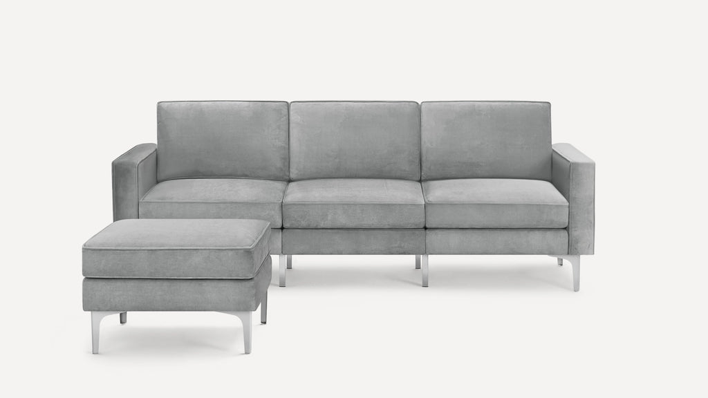 Modern grey three-seater sofa with matching cushioned ottoman, featuring sleek metal legs and clean-lined design.