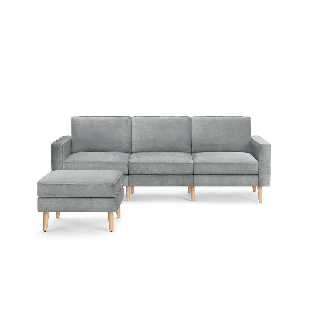modern light gray fabric sectional sofa with wooden legs and clean lines on the back, featuring a chaise lounge and matching ottoman