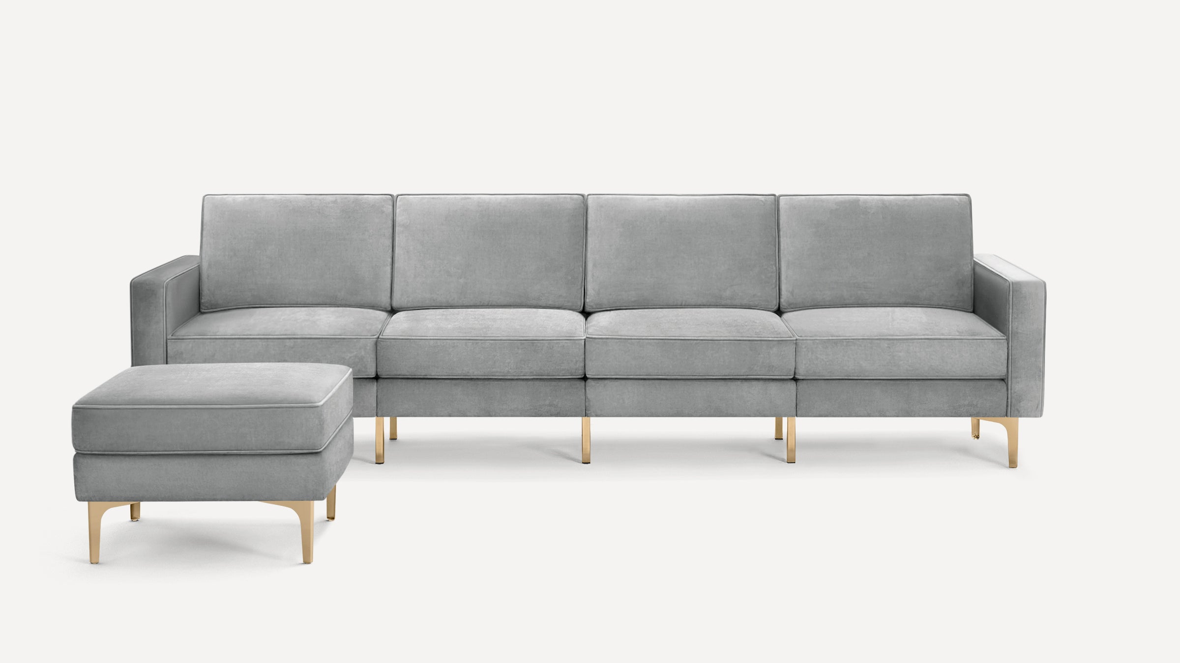 Modern light gray velvet sofa with clean lines and matching cushioned ottoman, supported by sleek gold metal legs.