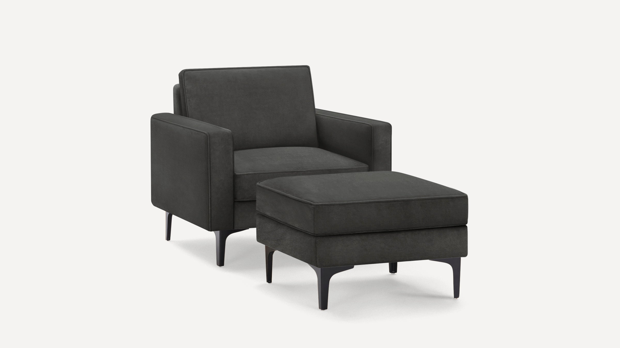 Dark gray upholstered armchair with matching ottoman, featuring slim black legs and clean, modern design.