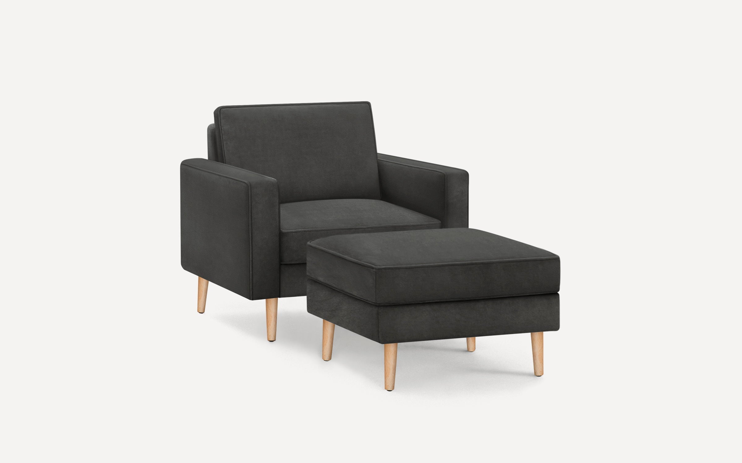 Dark gray upholstered armchair with matching ottoman, both featuring wooden legs and clean, modern design.