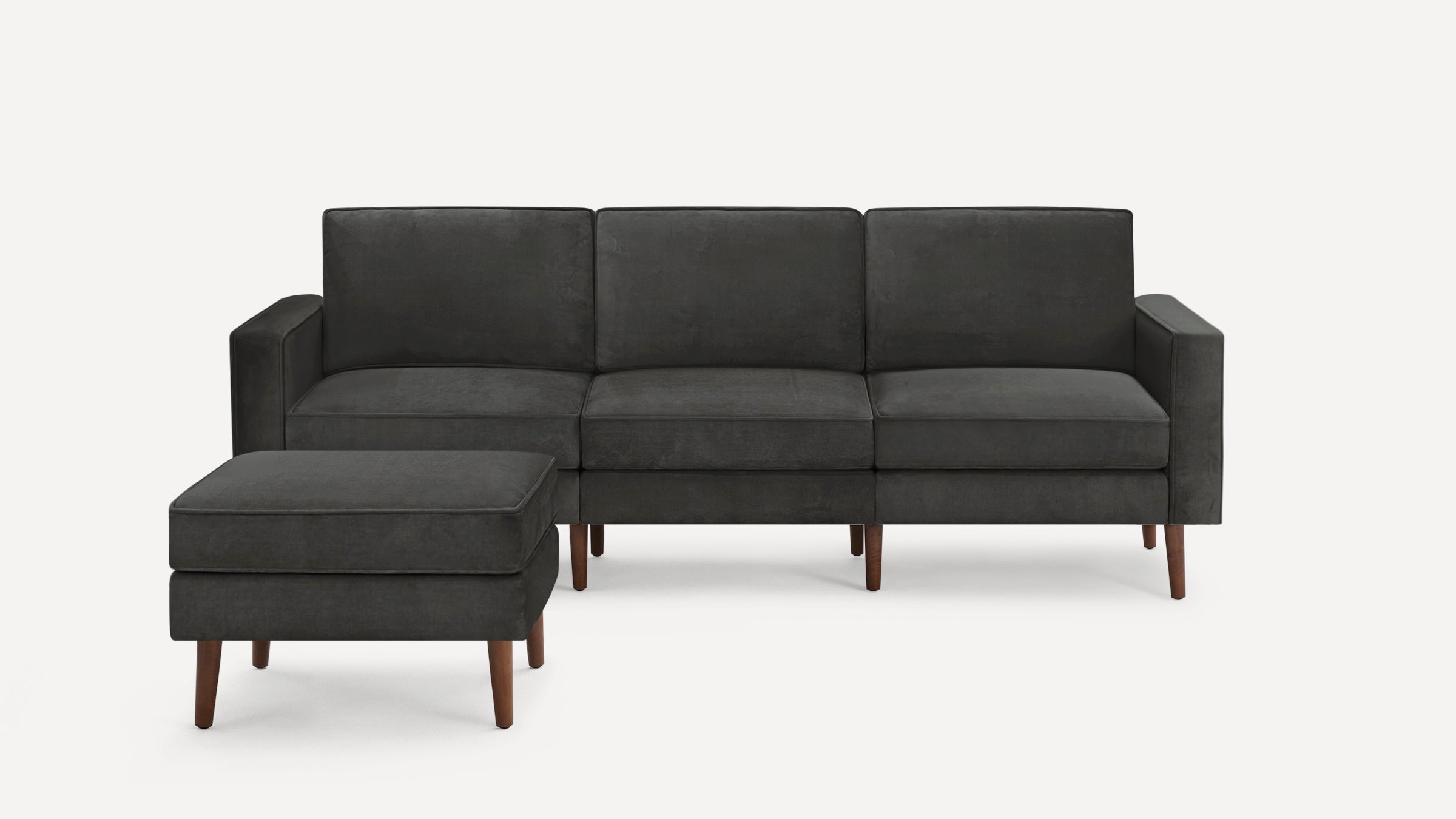 Dark gray modern three-seater sofa with matching ottoman, featuring wooden legs and clean, straight armrests.