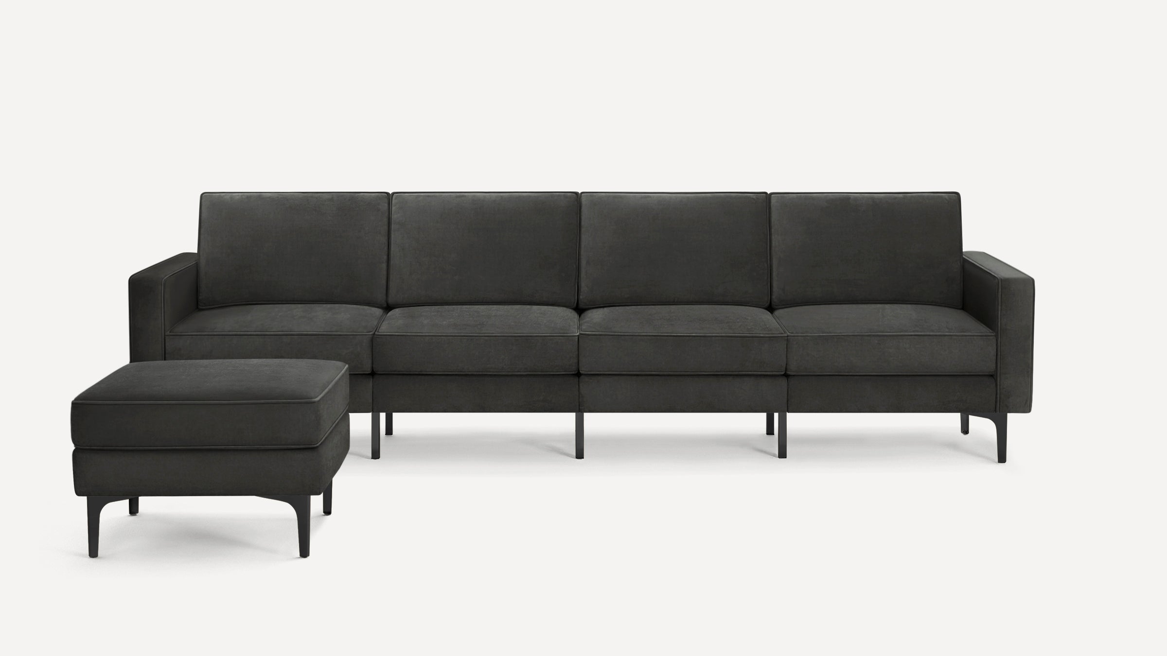Dark gray modern sectional sofa with clean lines, square arms, and matching ottoman, supported by sleek black legs.