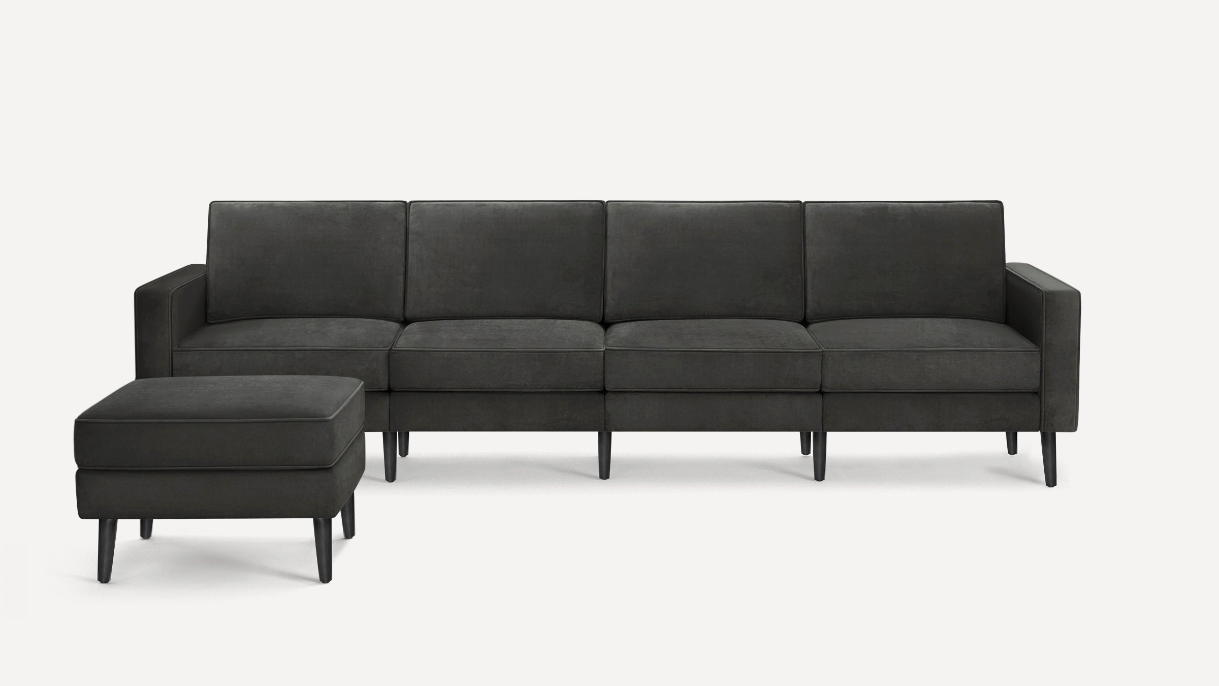 Modern dark grey fabric sectional sofa with clean lines, slim black legs, and matching ottoman for versatile seating.