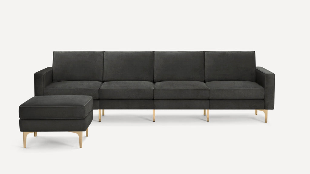 Modern dark gray velvet sofa with matching ottoman, gold metal legs, and clean, rectangular design.