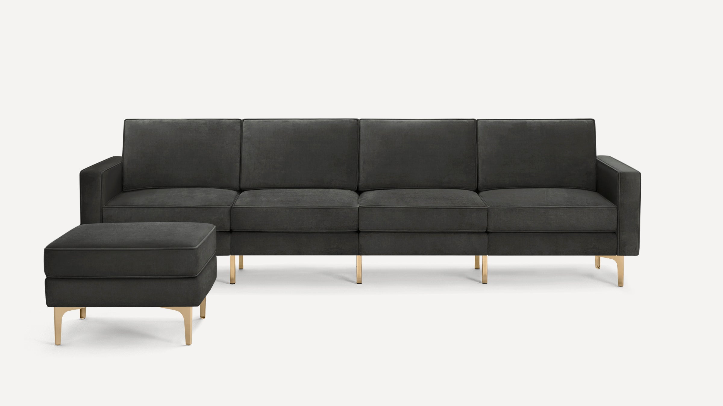 Modern dark gray velvet sofa with matching ottoman, gold metal legs, and clean, rectangular design.