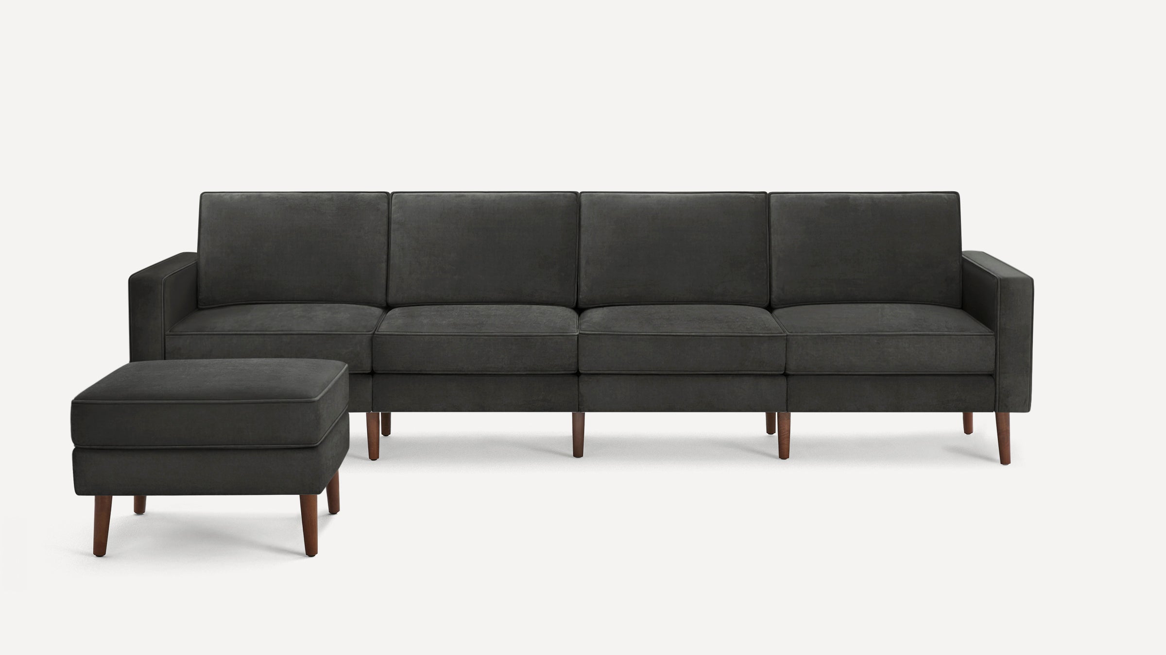 Dark gray modern four-seat sofa with matching ottoman, featuring wooden legs and clean, minimalist design.