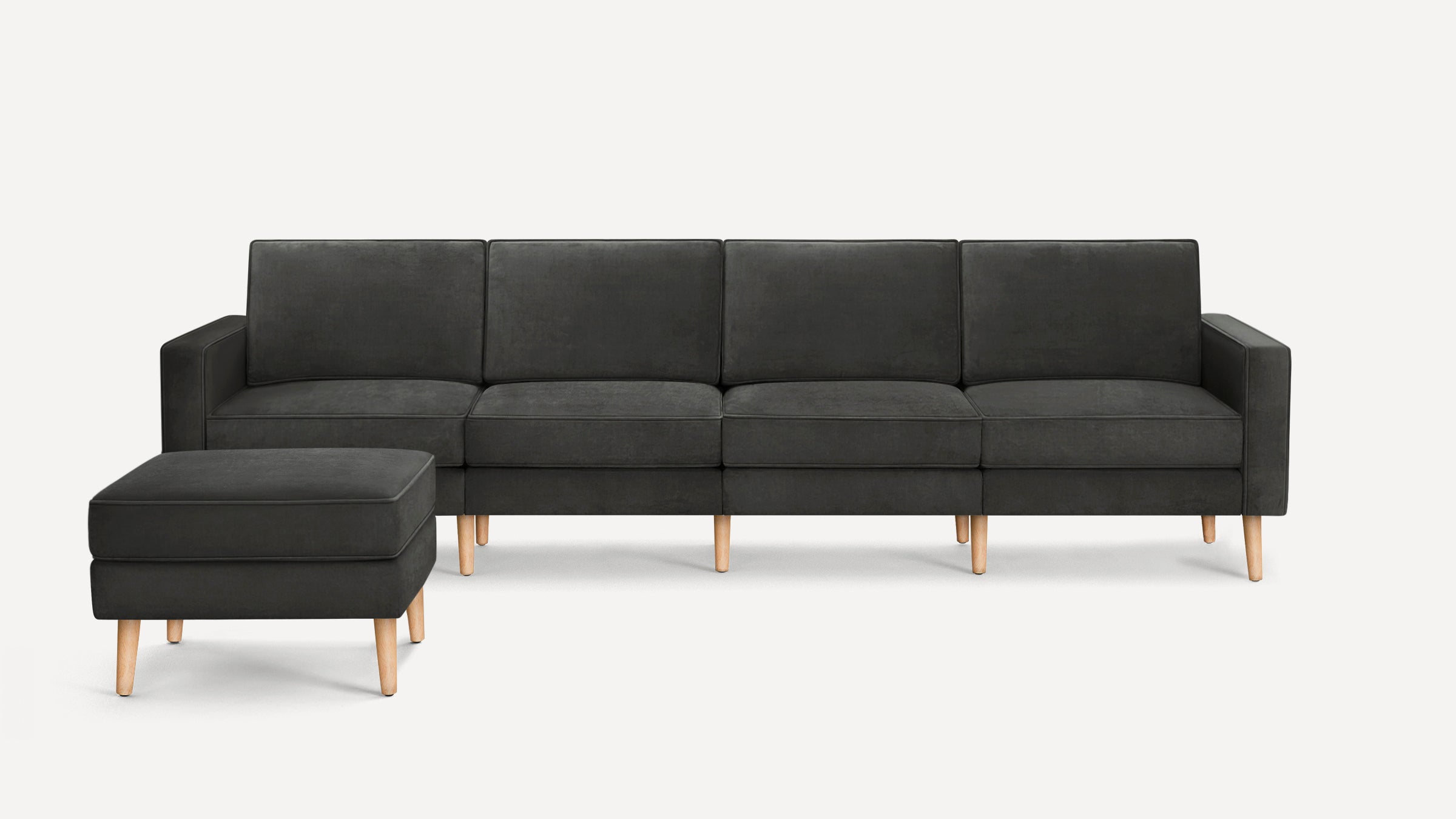 Modern dark gray fabric sectional sofa with matching ottoman, featuring clean lines and light wooden legs.