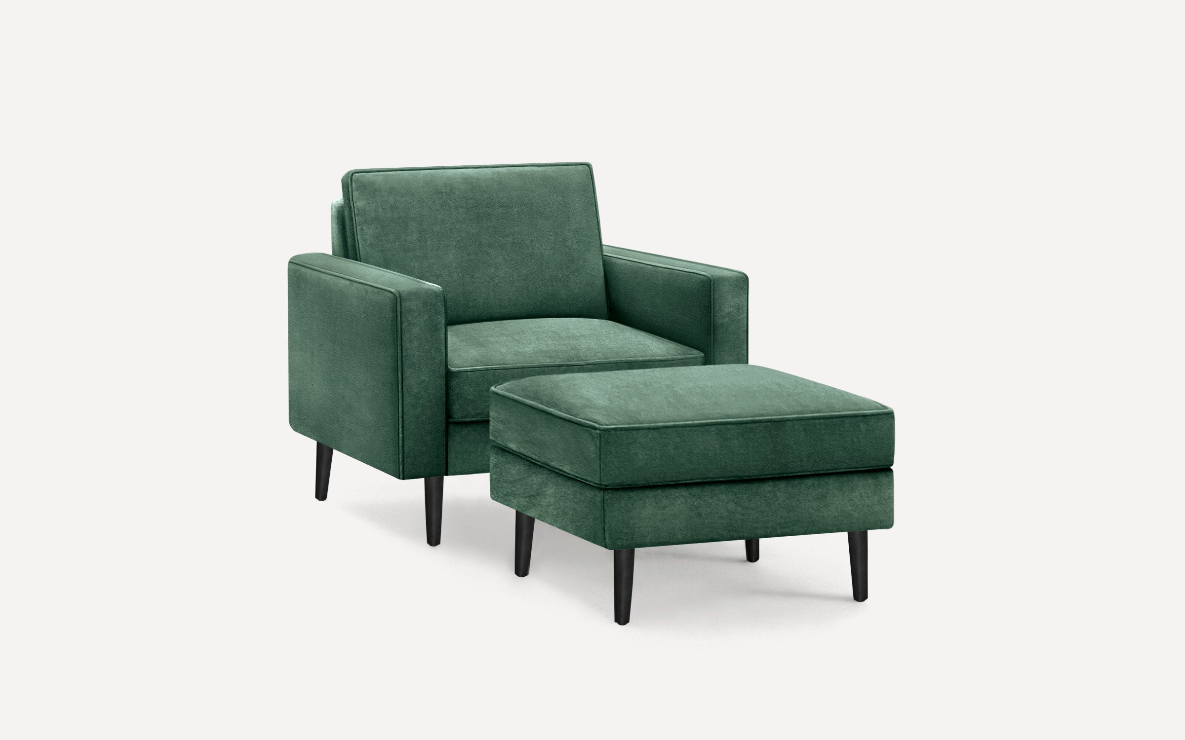 Green upholstered armchair with matching ottoman, both featuring black tapered wooden legs and clean, modern lines.
