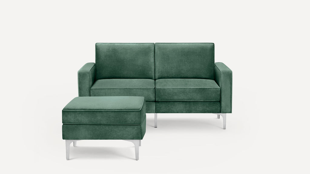 Green velvet loveseat with matching ottoman, featuring modern silver metal legs and clean, rectangular lines.