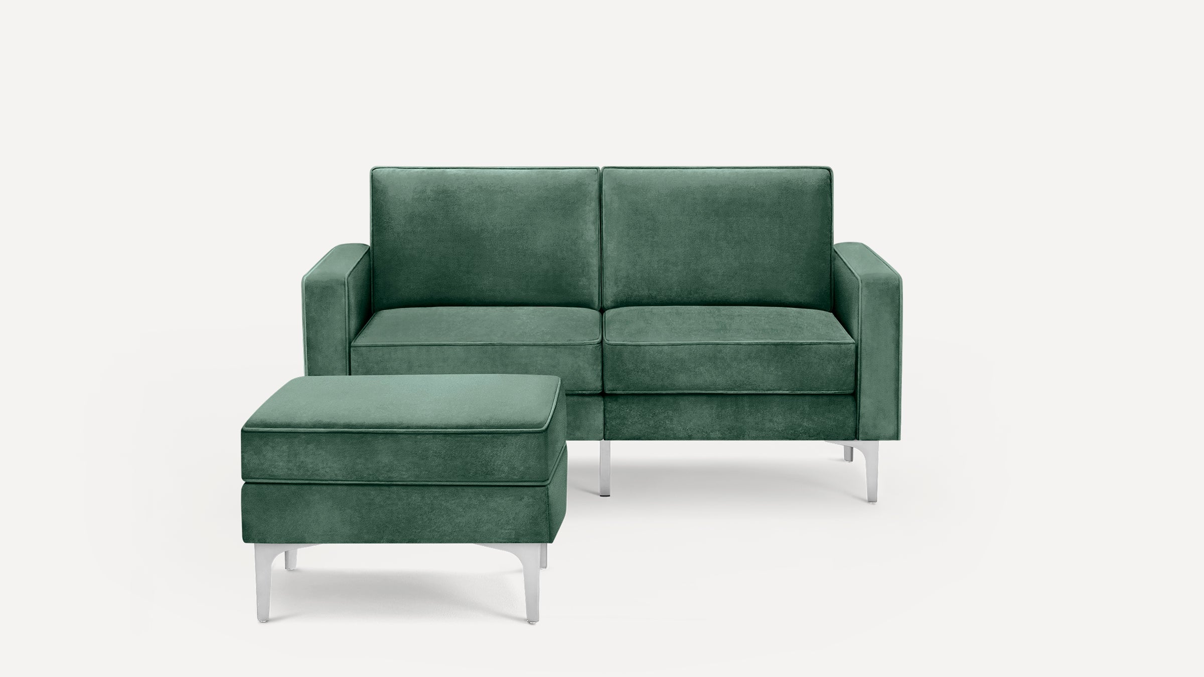 Green velvet loveseat with matching ottoman, featuring modern silver metal legs and clean, rectangular lines.