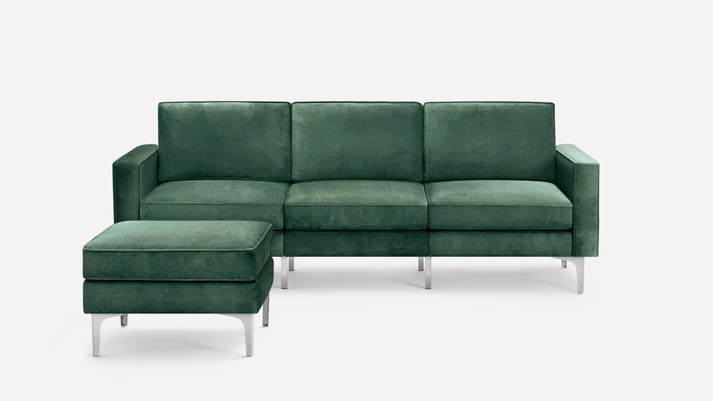 Modern green velvet three-seater sofa with matching ottoman, featuring silver metal legs and clean, straight lines.