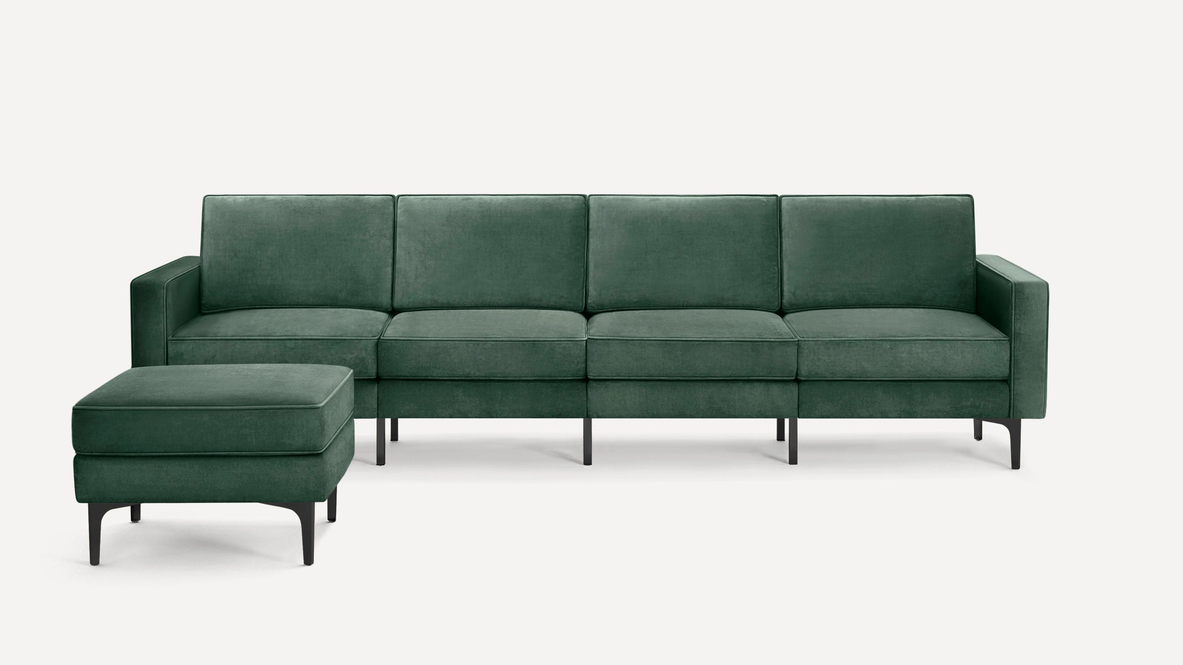 Modern dark green velvet sectional sofa with black legs, featuring four seat cushions and a matching ottoman.