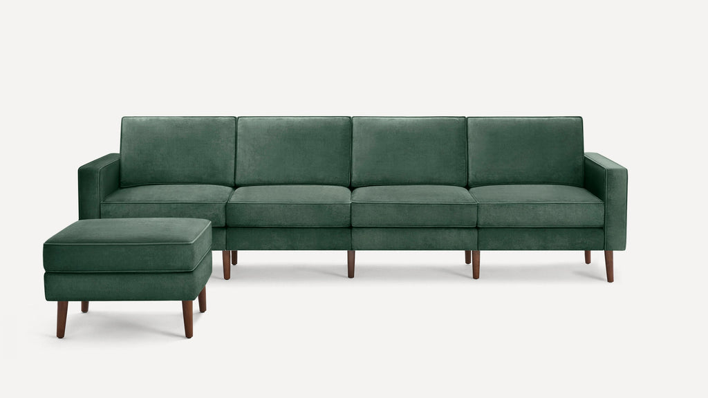 Dark green velvet sectional sofa with clean lines and wooden legs, accompanied by a matching ottoman.