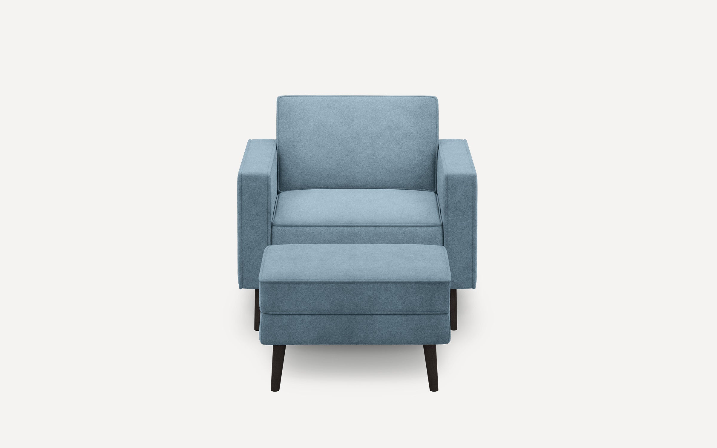Modern blue upholstered armchair with matching ottoman, featuring clean lines and dark wooden tapered legs, shown on white background.