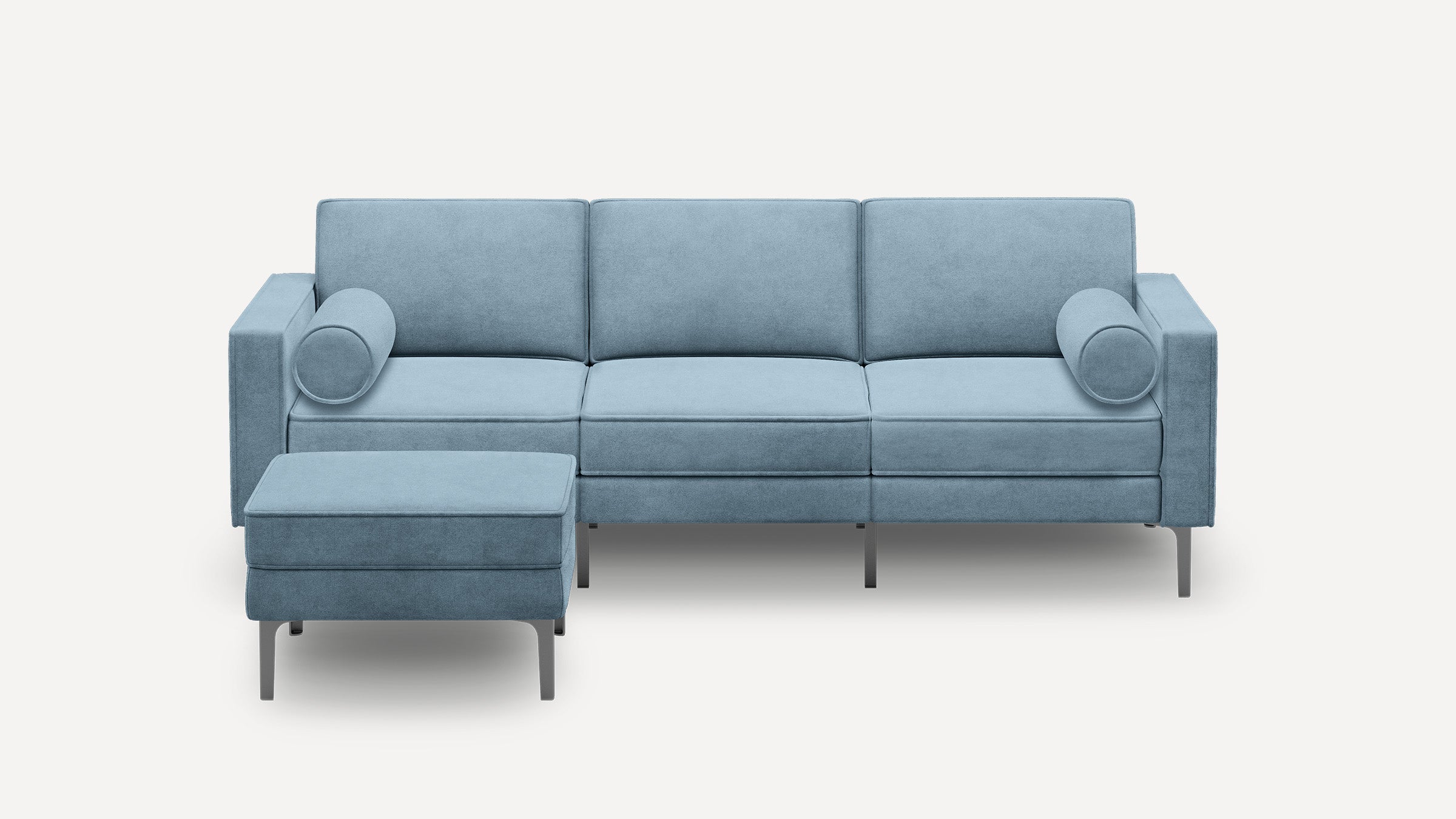 Light blue modern three-seater sofa with clean lines, two cylindrical bolster pillows, and a matching rectangular ottoman on metal legs.