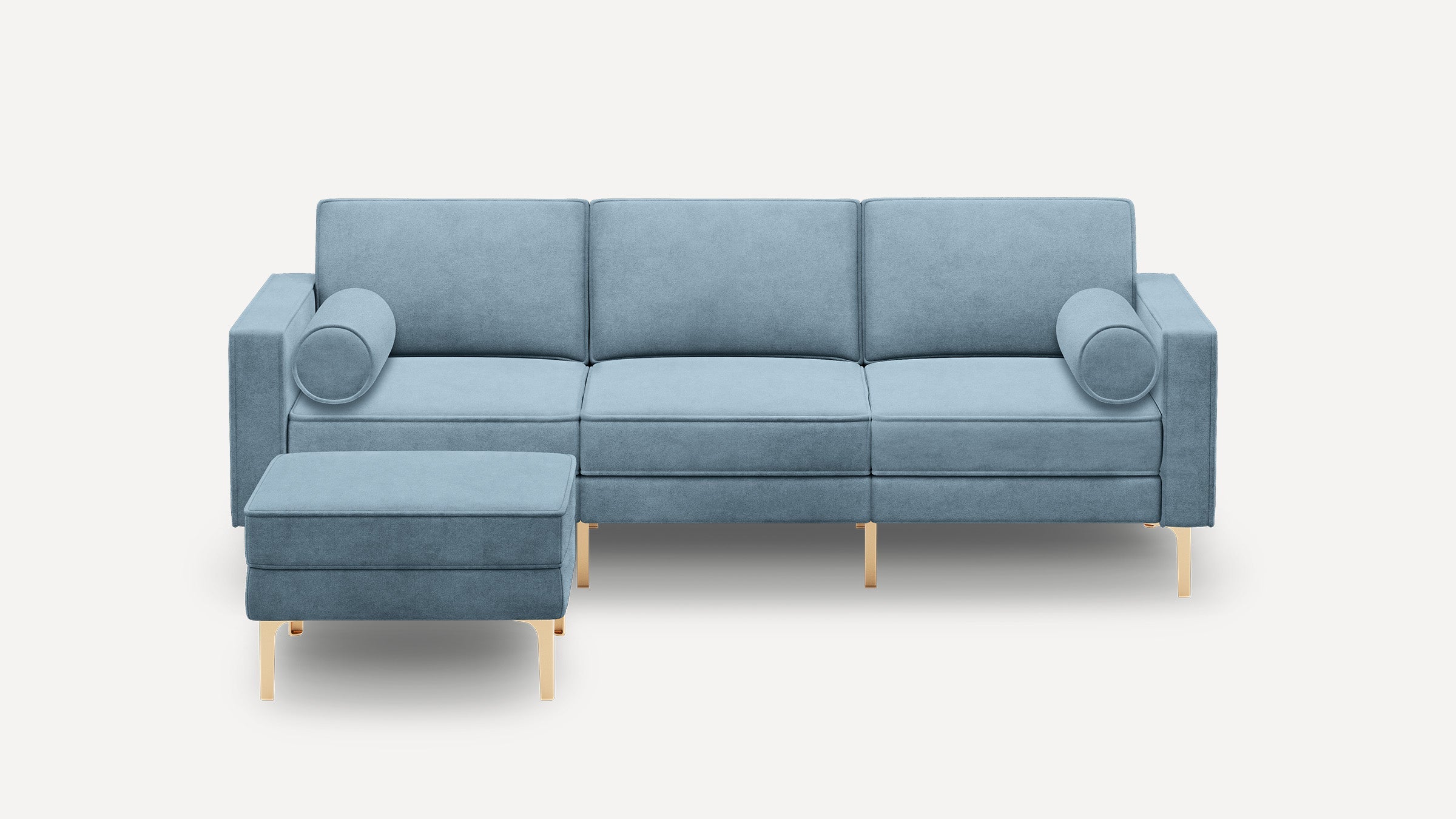 Light blue modern three-seater sofa with two cylindrical bolster pillows and a matching ottoman, all supported by slim gold legs.