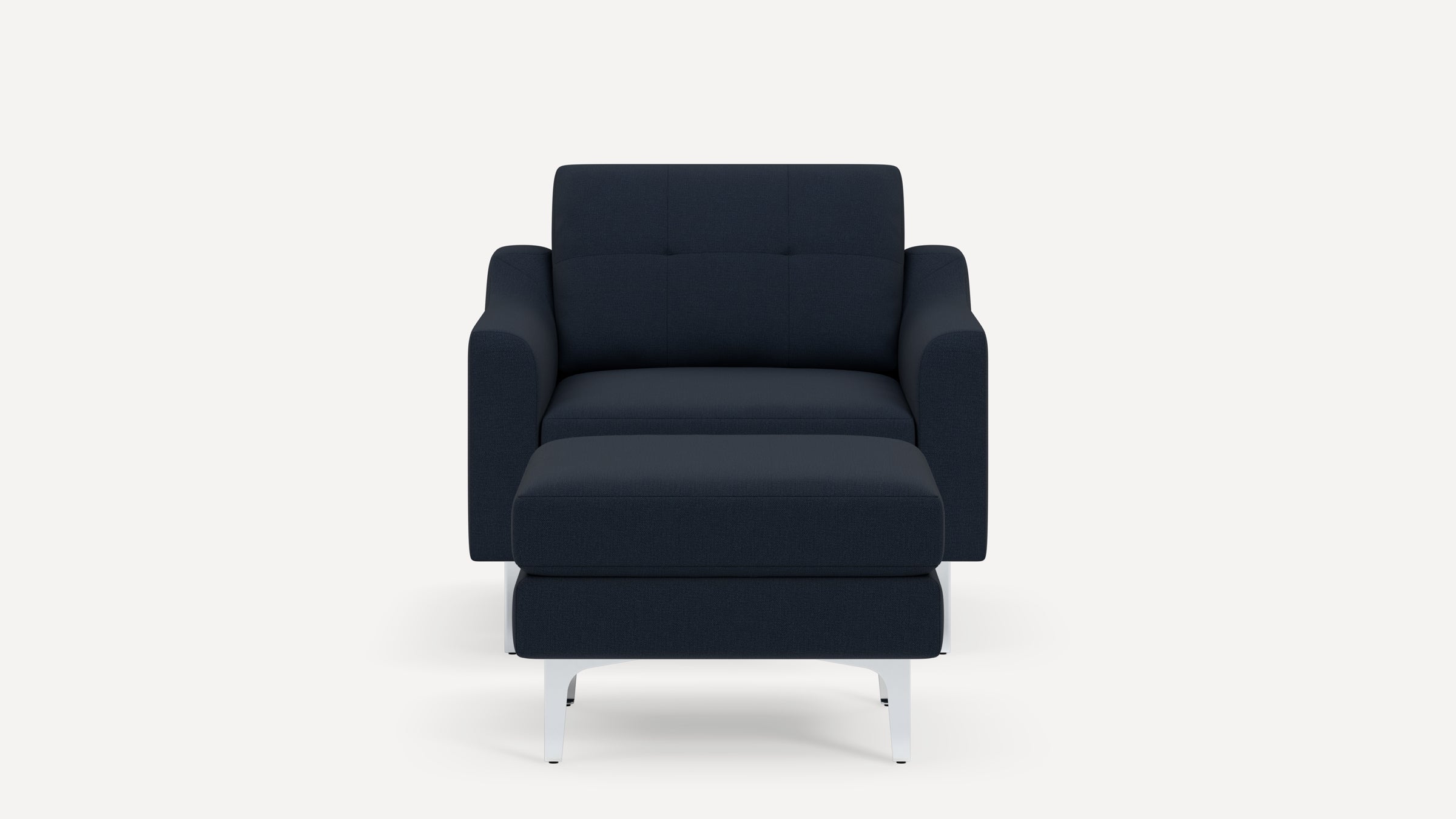 Modern navy blue upholstered armchair with matching ottoman and angled white metal legs on a plain background.