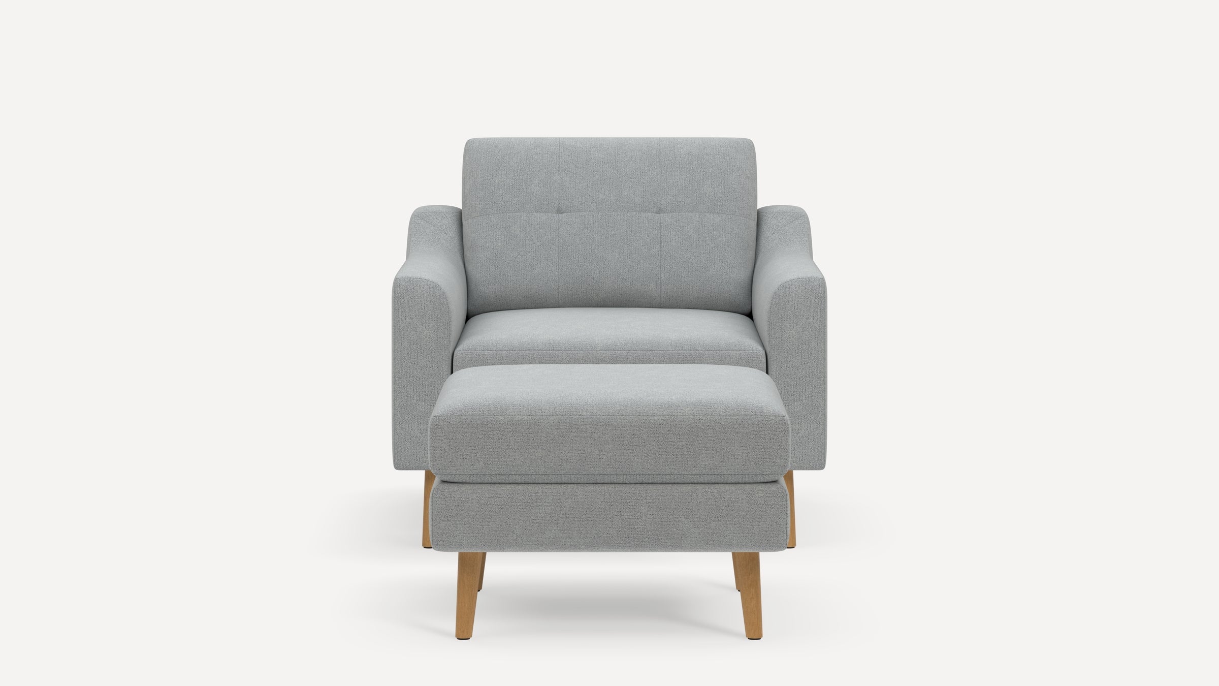 Front view of a modern light gray upholstered armchair with a matching ottoman and wooden legs on a white background.