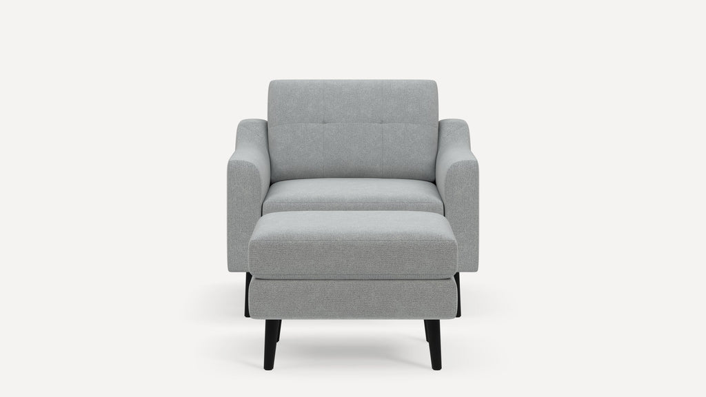 Front view of a modern light gray upholstered armchair with black tapered legs and cushioned seat and backrest.