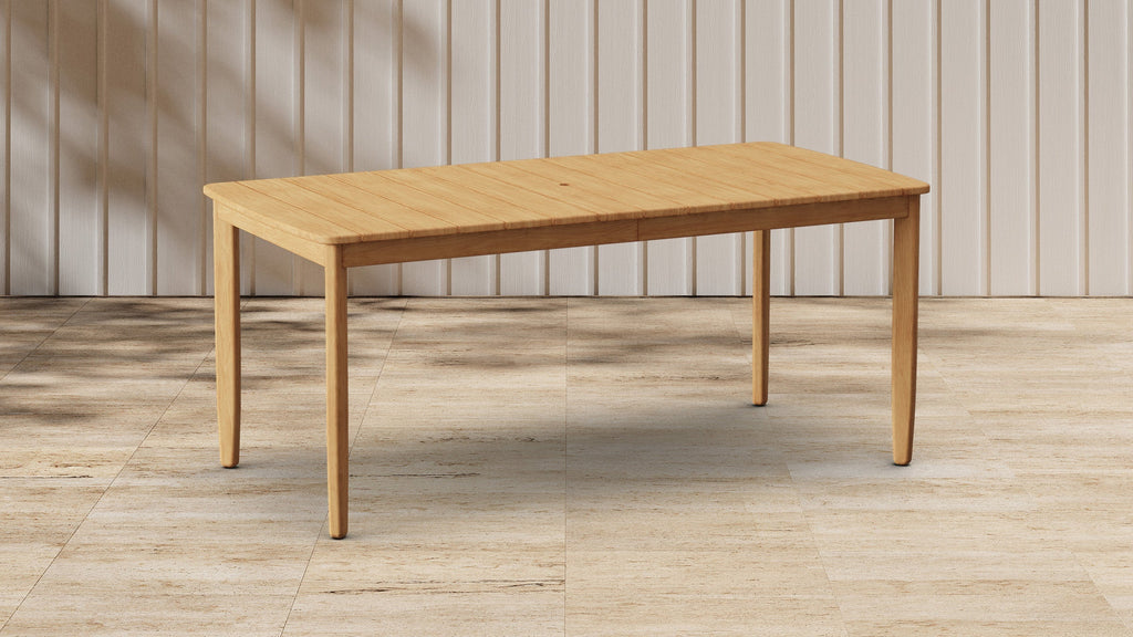 Rectangular wooden dining table with smooth surface and rounded edges, standing on four tapered legs in minimalistic room.