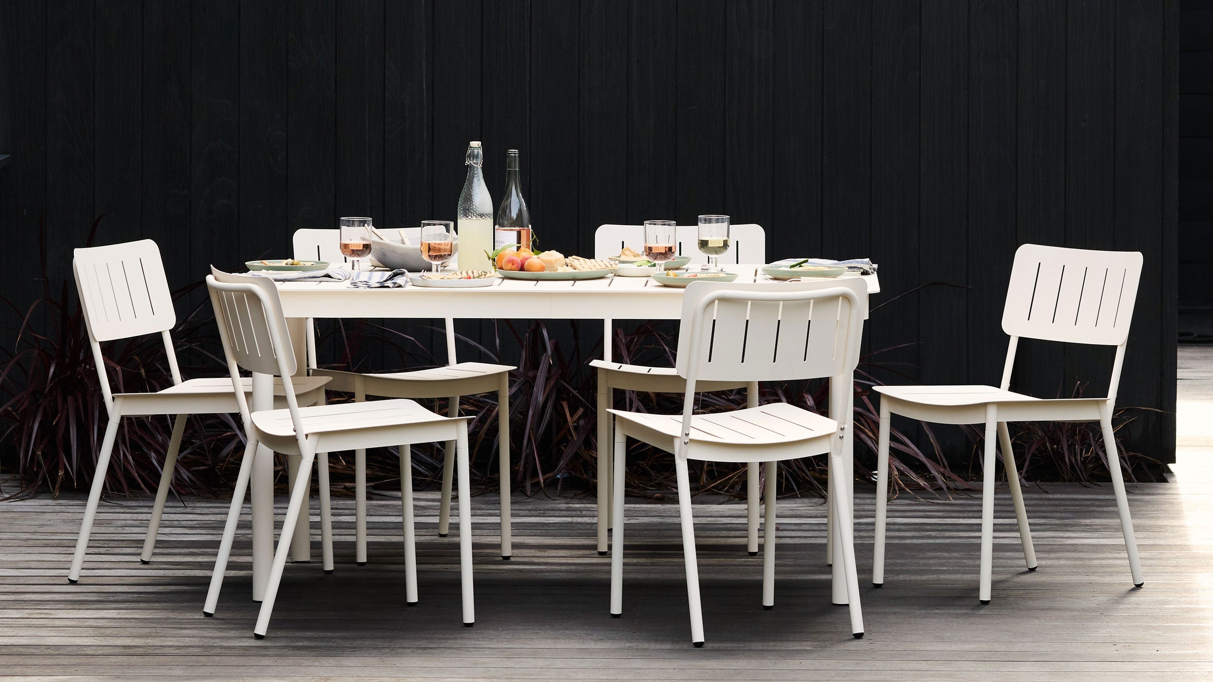 a table with four chairs and a bottle of wine on it