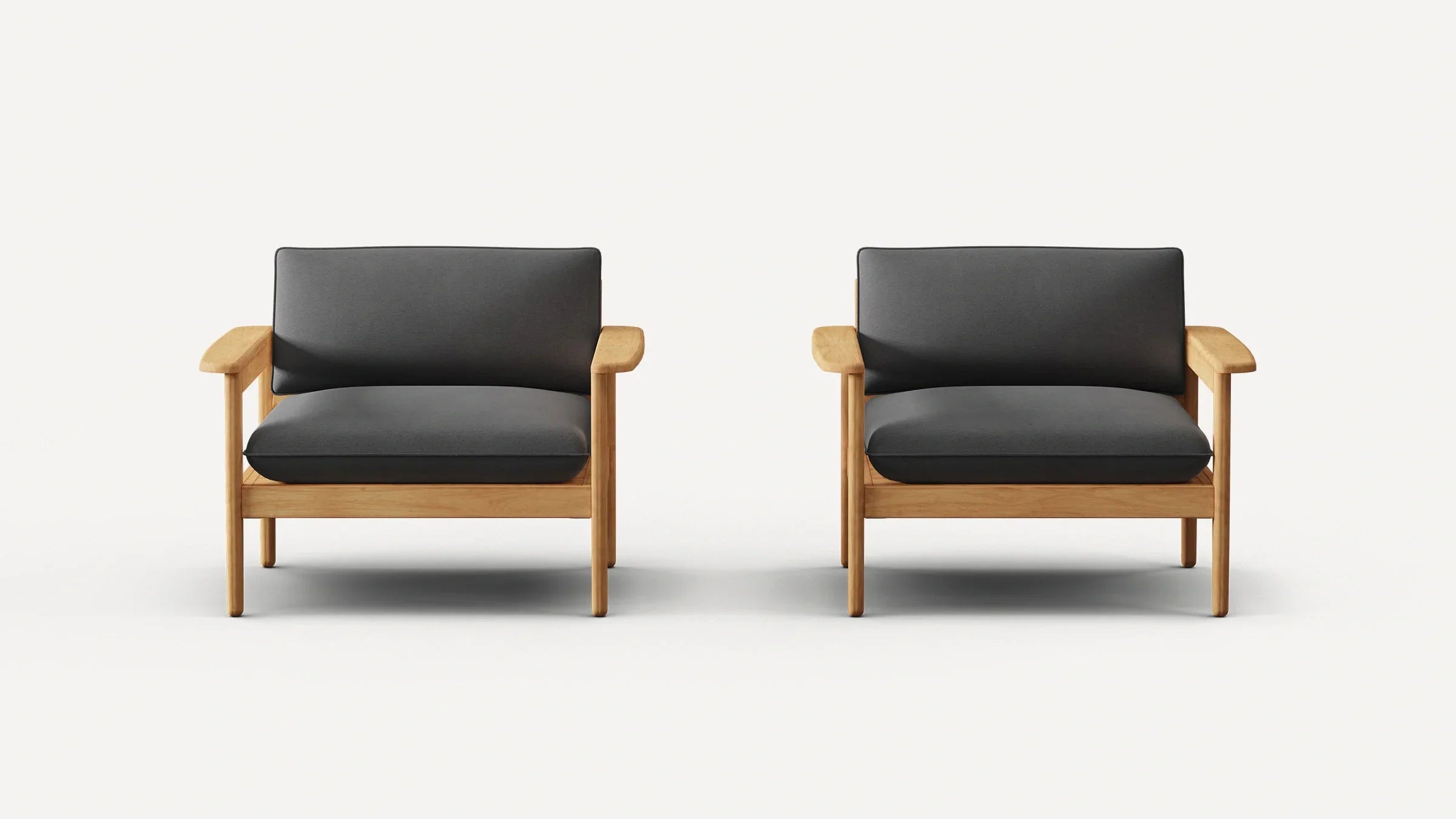 Two identical modern armchairs with light wood frames and dark gray cushions, set against a plain white background.