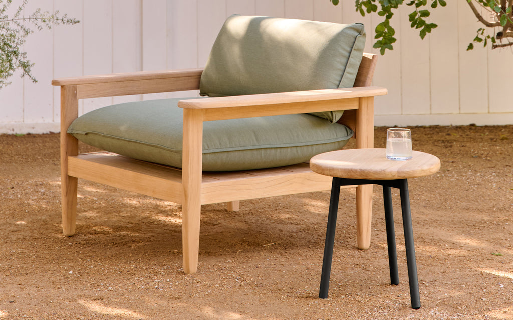 a wooden chair with a green cushion and matching side table
