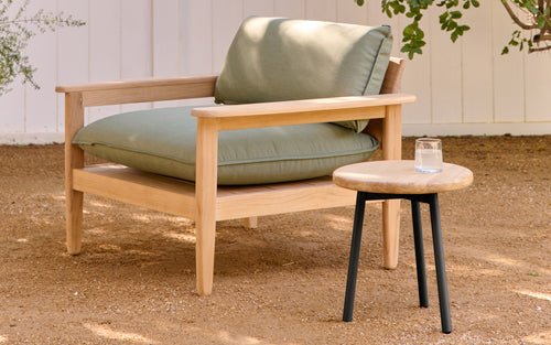 a wooden chair with a green cushion and matching side table