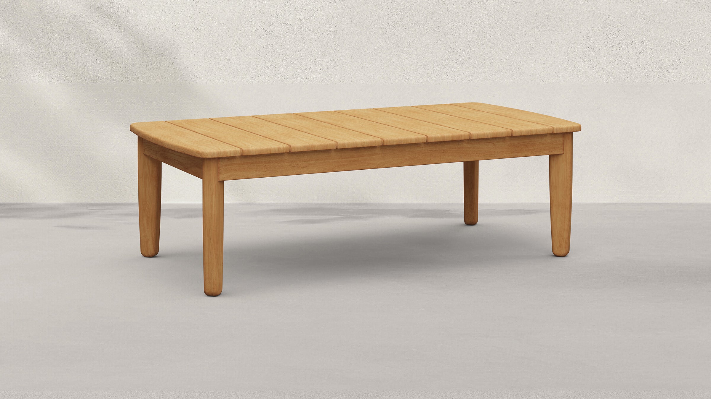 Rectangular wooden coffee table with slatted top and rounded corners, supported by four sturdy, tapered legs.
