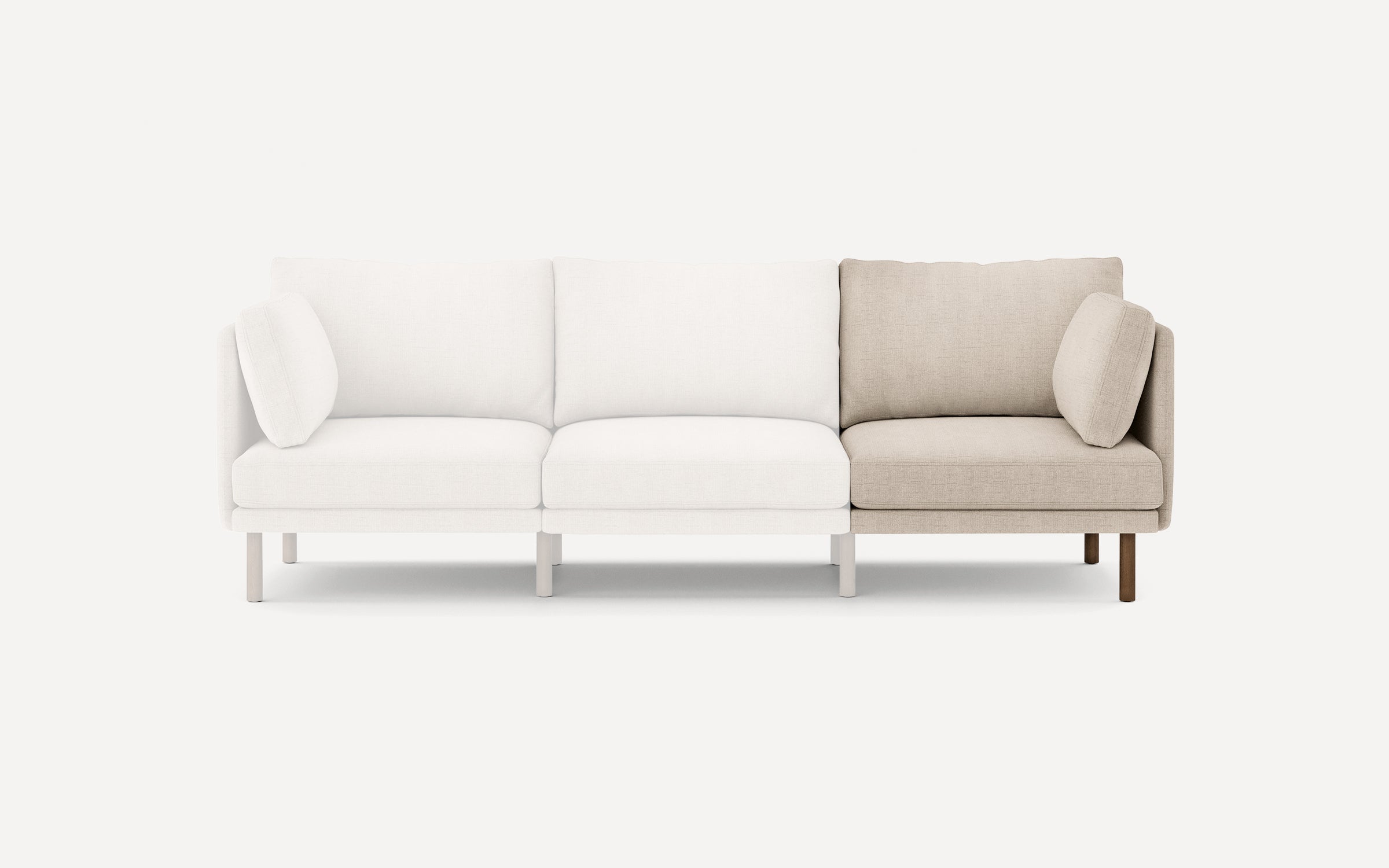 Modern sectional sofa with three seats, featuring light beige and cream fabric upholstery and wooden legs.