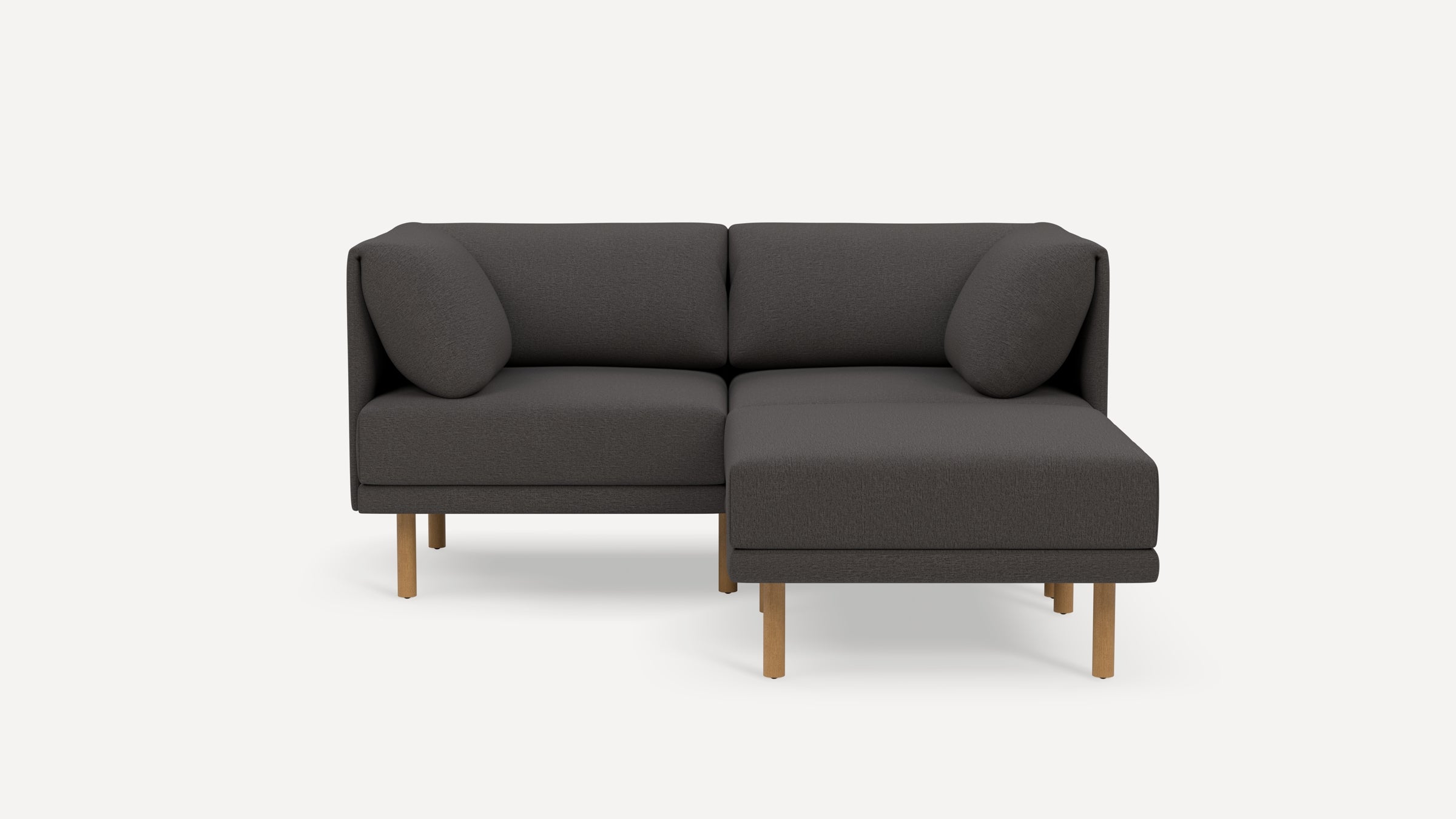 Modern dark gray fabric sectional sofa with wooden legs, featuring a chaise lounge on the right side and two round cushions.