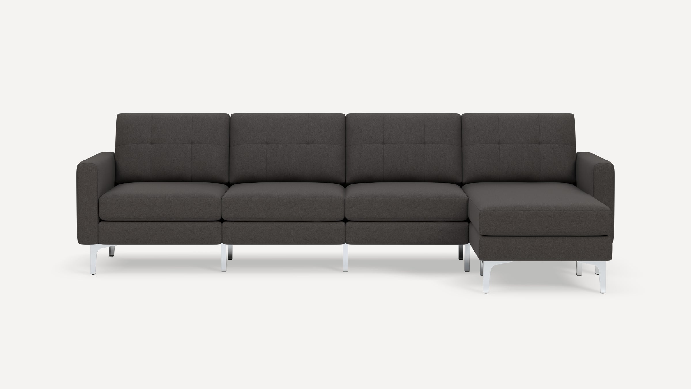 Modern dark gray sectional sofa with tufted back cushions, an extended chaise on the right, and sleek silver metal legs.