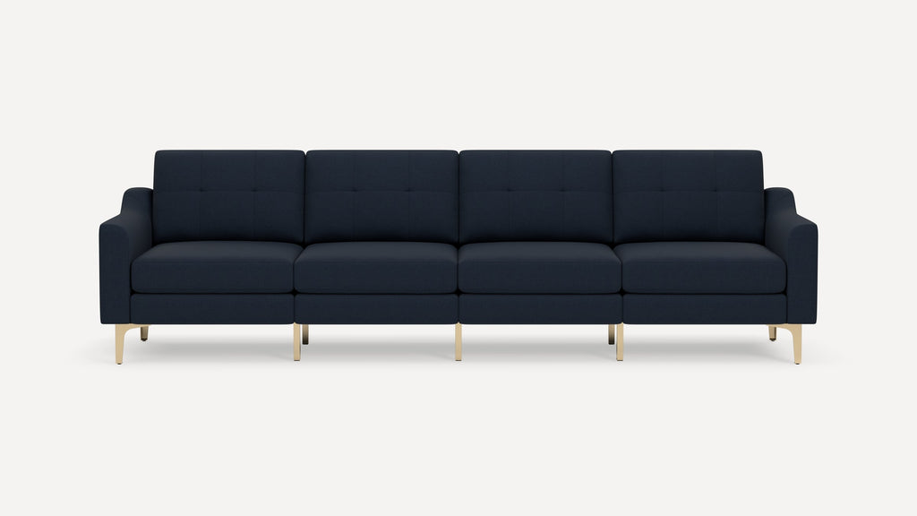 Modern navy blue four-seater sofa with tufted cushions, curved armrests, and sleek gold metal legs on a white background.
