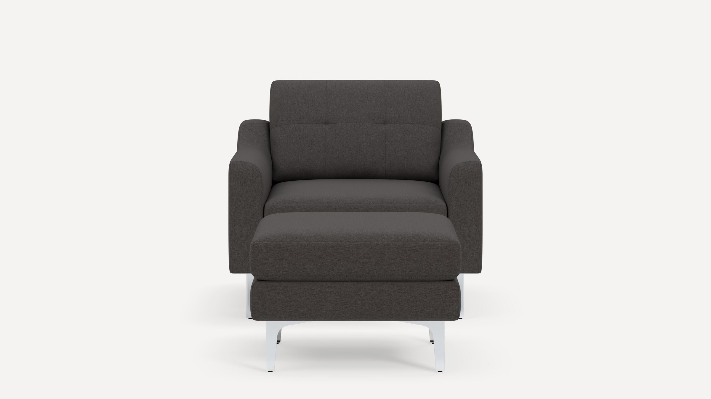Front view of a modern dark gray upholstered armchair with matching ottoman and sleek white legs.