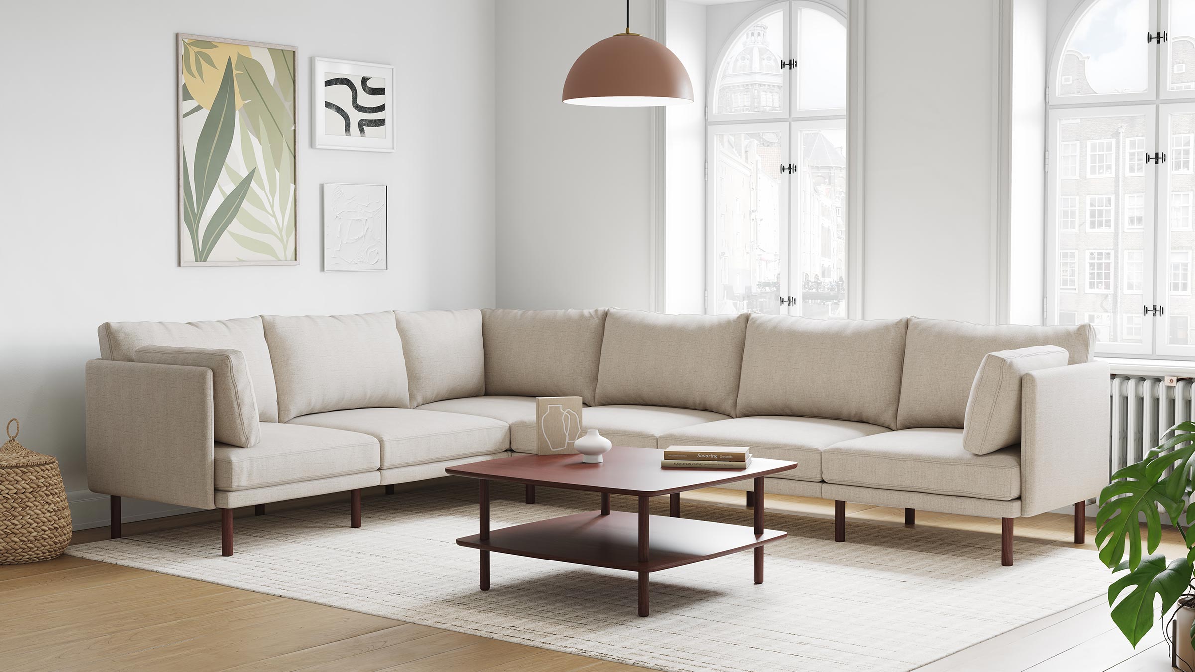 Beige sectional sofa with square cushions in a bright living room, accompanied by a brown coffee table and modern wall art.