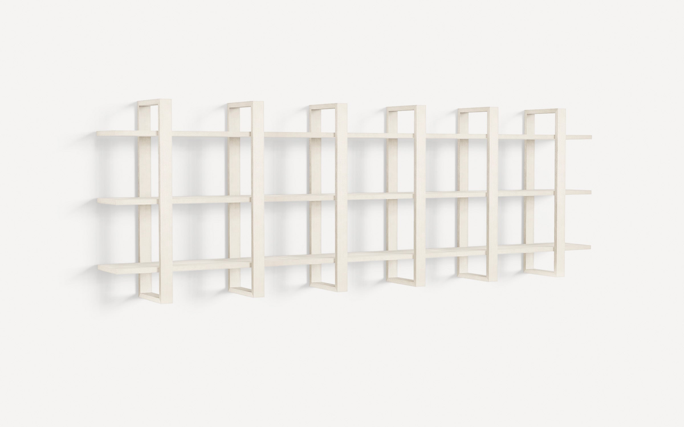 Modern wall-mounted shelving unit with five vertical dividers and three horizontal shelves, in a light wood finish.